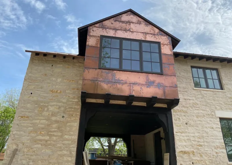 Copper metal panel facade on a stone building for Roof Repair in Palm Valley